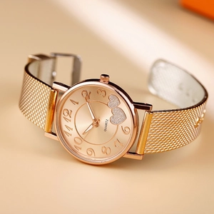 Detail of rose gold mesh strap watch with heart motifs and Arabic numerals dial