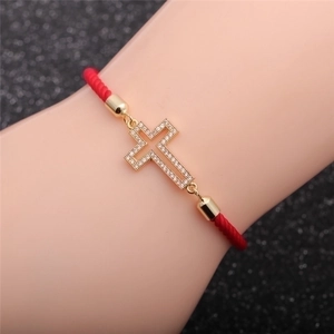Bracciale in corda rossa con croce dorata e pavé di zirconi per un look elegante