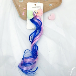 Close-up of unicorn rainbow bow hair clip with colorful braided synthetic hair extensions