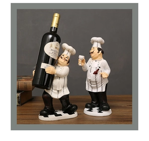 Detail of two resin chef figurines holding a wine bottle and glass on a wooden table