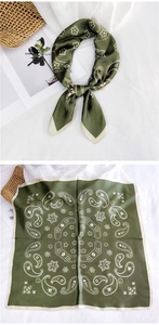Detail of dark green square scarf featuring paisley patterns and satin texture
