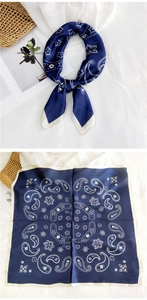 Detailed view of navy blue paisley silk scarf with satin texture and ivory border