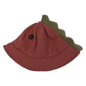 Détail du chapeau bob enfant en velours brique avec crête de dinosaure verte et œil bouton