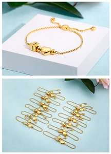 Detail of adjustable heart bracelet with golden alphabet cubes and sliding clasp