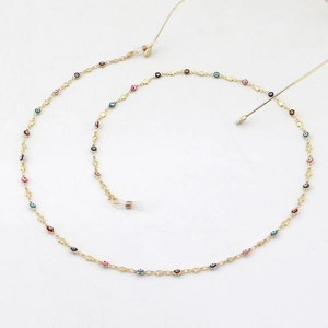 Golden metal eyewear chain with colorful enamel evil eyes and star charms on white background