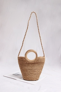 Detailed view of handmade woven straw bag with round handles and natural textures