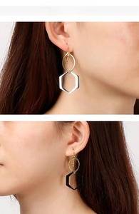 Vue détaillée de boucles d'oreilles hexagonales avec anneaux dorés et glands longs