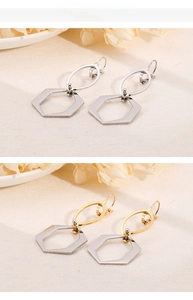 Détail de boucles d'oreilles hexagonales en argent et bicolore sur une surface texturée neutre