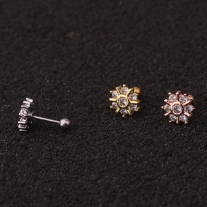 Close-up of snowflake zircon stud earrings in silver, gold and rose gold finishes