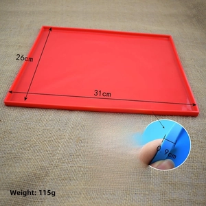 Detail of red silicone cake roll mat with spill-proof raised edges 31x26cm dimension
