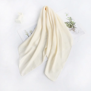 Artistic display of beige silk scarf draped over a classical bust on an open magazine