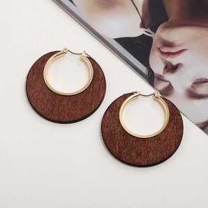 Orecchini retrò in legno con anello interno in metallo dorato su rivista di moda