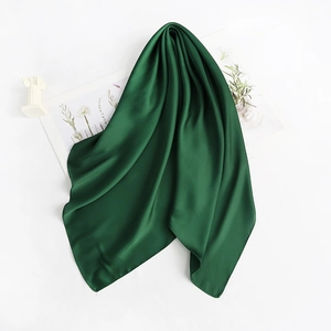 Close-up of a dark green satin silk scarf with elegant folds and glossy finish