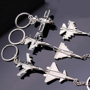 Set of 6 silver metal fighter jet and aircraft model keychains on a dark surface
