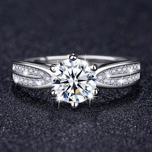 Macro shot of six-prong moissanite engagement ring with micro-pave diamonds on band