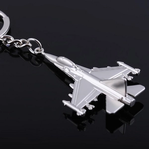 Macro shot of silver metal fighter jet keychain showing realistic wing details and finish