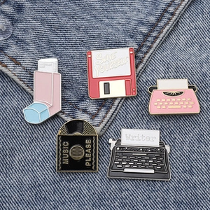 Gros plan de pins en émail rétro avec disquette et disque vinyle sur veste en denim