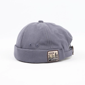 Close-up of a grey-blue canvas miki hat with denim supplies patch and metal buckle