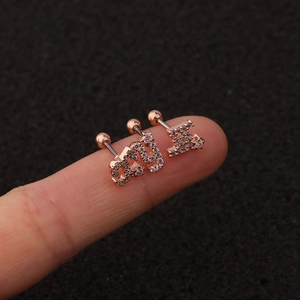 Rose gold alphabet stud earrings with rhinestones B, A, Y on finger for size perspective