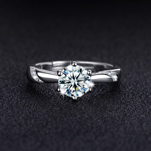 Macro shot of a brilliant round cut zircon ring with classic six-prong setting on black texture
