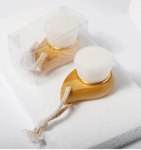 Close-up of wooden facial cleansing brushes with soft white bristles and hemp hanging loops