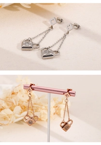 Detail view of heart-lock tassel earrings with clover studs in silver and rose gold finish