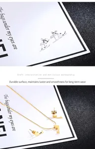 Close-up of dolphin stud earrings and necklace set in silver and gold finish