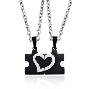 Detail of puzzle piece couple necklaces forming a heart in black and silver steel