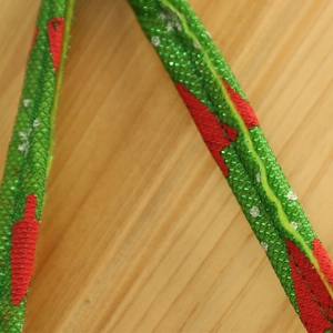 Makroaufnahme einer grünen Pailletten-Weihnachtstüte mit festlichem Schneeflockenmuster