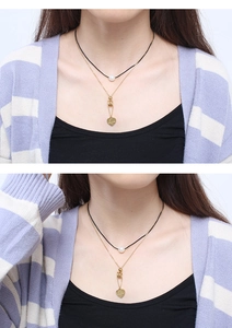 Close-up of double-layered gold necklace with pearl choker and engraved Love heart pendant