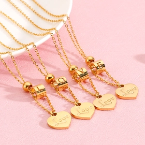 Minimalist gold heart necklaces engraved with Love on a soft pink background