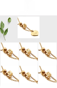 Detailed close-up of 18K gold heart pendant with Love engraving and alphabet beads