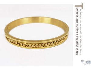 Macro view of gold chain link inlay pattern on polished stainless steel bracelet