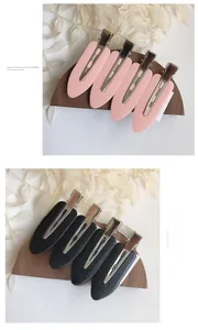 Detail view of pink and black matte seamless hair clips set on a wooden display stand