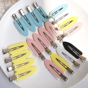 Creaseless hair clips set in macaron colors neatly arranged in a white ceramic plate