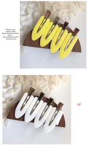 Detailed close-up of yellow and white seamless hair clips on a wooden display stand