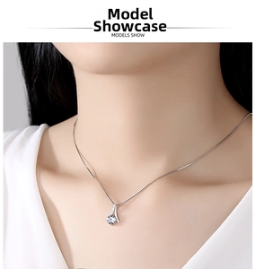 Close-up of a S925 sterling silver necklace featuring a round zircon pendant on a model