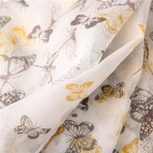 Close-up of lightweight fabric with yellow and grey butterfly and dragonfly patterns