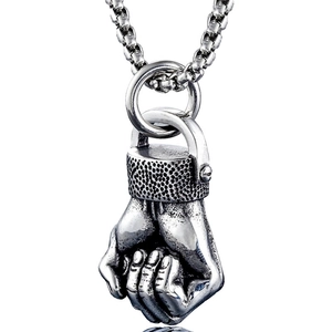Detailed view of a silver fist pendant necklace featuring realistic metal textures