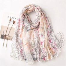 Detailed view of floral cotton scarf with delicate lace trim and colorful pony patterns