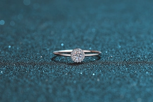 Macro shot of S925 sterling silver halo ring with round moissanite on blue background