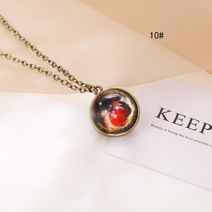Close-up of bronze celestial necklace with galaxy pendant on elegant fabric background