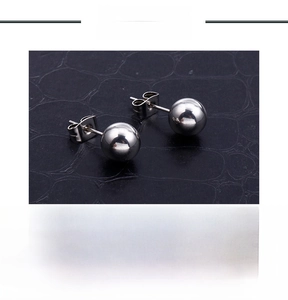 Macro shot of polished stainless steel ball stud earrings with product specifications