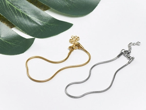 Detail of adjustable 18K gold and silver snake bone chain bracelets with lobster clasps