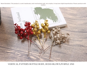 Detailed view of glittering Christmas berry picks in red, gold, and silver for DIY decor