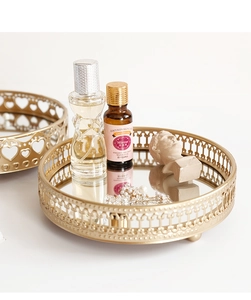 Macro detail of gold metal mirrored tray featuring intricate heart shaped cutout design