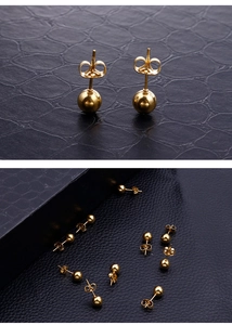Detail of 18k gold plated stainless steel ball stud earrings on a black leather texture