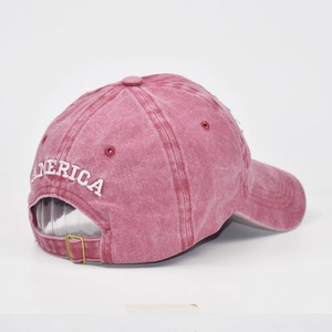 Dettaglio della fibbia in metallo e ricamo bianco America su cappellino in cotone bordeaux
