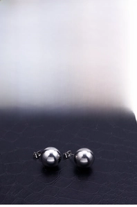 Macro shot of polished stainless steel ball stud earrings with mirror finish and pins