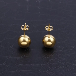 Polished 18k gold plated stainless steel ball stud earrings on black texture